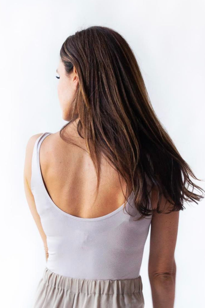 Model in organic cotton bodysuit light grey back view