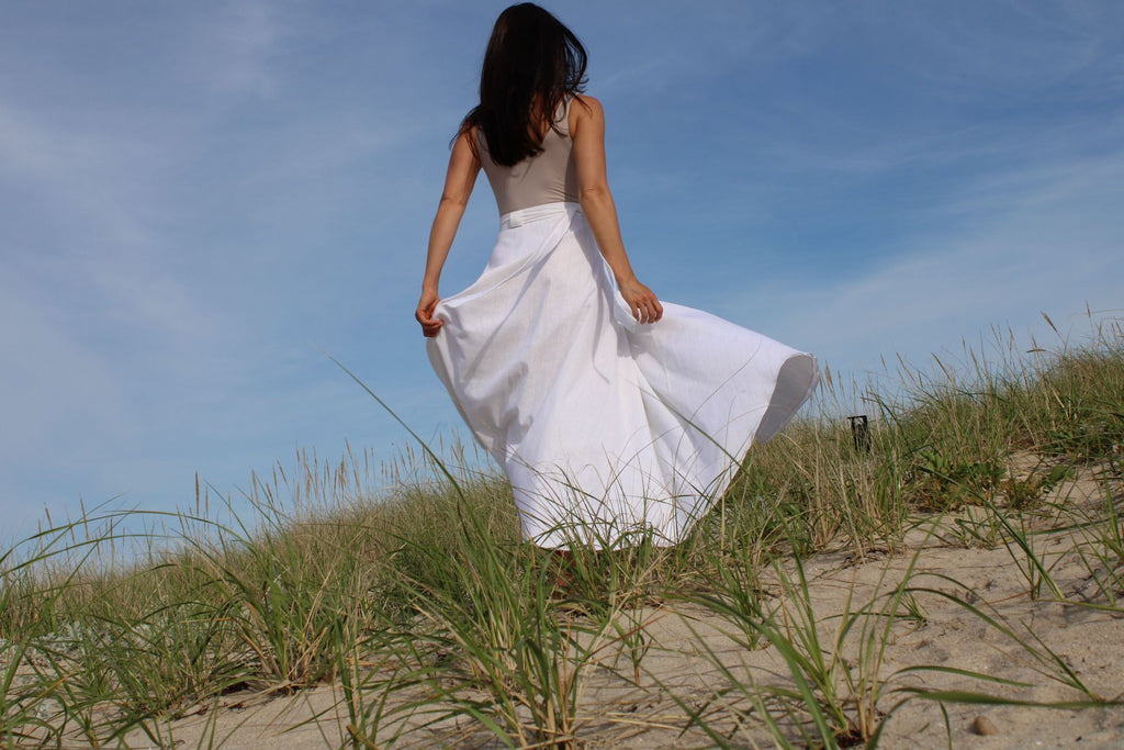 Rachel Ackley in linen healer skirt in white on the beach back view